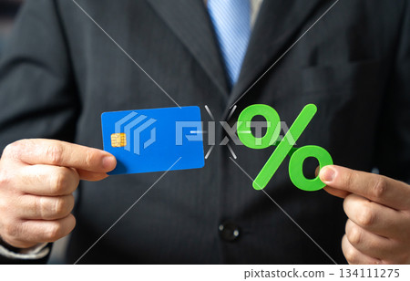 A credit card and green interest in the hands of a businessman. Favorable terms, cashback, and interest on deposits. Profitable banking and smart spending. Consumer finance, savings strategy. A credit card and green interest in the hands of a businessman. Favorable terms, cashback, and interest on deposits. Profitable banking and smart spending. Consumer finance, savings strategy. 134111275