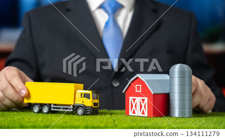 A businessman drives a truck to a farm. Establishing logistics in retail and agricultural production. Supply chain integration and rural delivery. Agribusiness, retail logistics and food distribution. 134111279