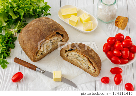 Finnish Kalakukko, fish pie on table with butter 134111415