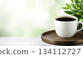 Fresh Coffee Cup on Wooden Tray with Green Leaves in Bright Background 134112727