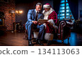 A man sitting on a couch next to a man dressed as Santa Claus 134113063