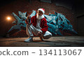 A man in a santa claus outfit crouching down with a can of spray paint 134113067
