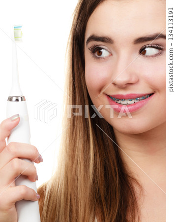 Woman brushing teeth with braces using brush 134113191