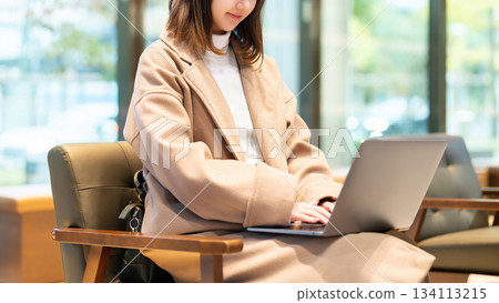 A woman using a computer in a cafe 134113215