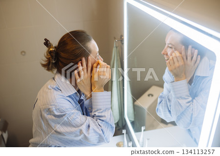 caucasian woman gently rubbing cream, beauty blogger moment 134113257