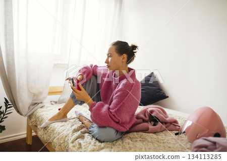 Female teenager engages in gaming with focused determination 134113285