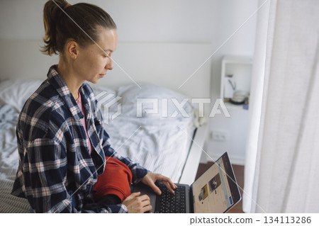 Focused mother manages studies during child care routines Focused mother manages studies during child care routines 134113286