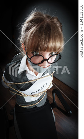 Businesswoman bound by contract with taped mouth. 134113316