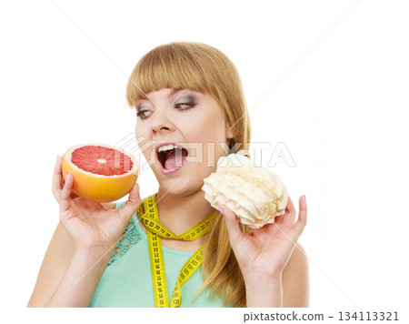 Woman choosing fruit or cake make dietary choice Woman choosing fruit or cake make dietary choice 134113321