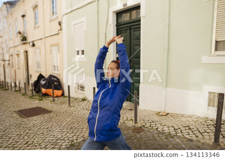 Gentle practitioner engaging in peaceful yoga amidst historic streets 134113346