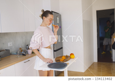 caucasian woman flipping pancake at stove, weekend baker caucasian woman flipping pancake at stove, weekend baker 134113402