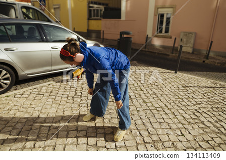 white maintenance worker inspecting cobblestone wearing earmuffs 134113409