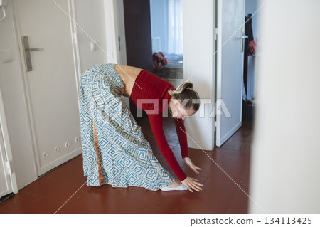 Graceful woman in patterned attire performing barefoot movement 134113425