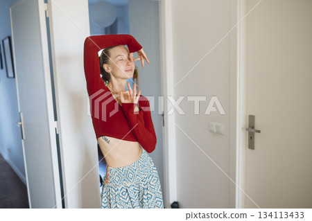 Female performer showcases energetic poses in distinct clothing 134113433