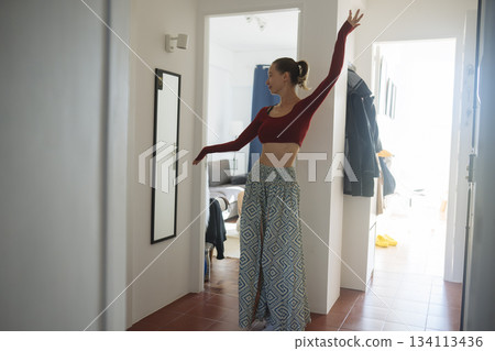 Caucasian lady models vivid expressive stance in corridor setting 134113436
