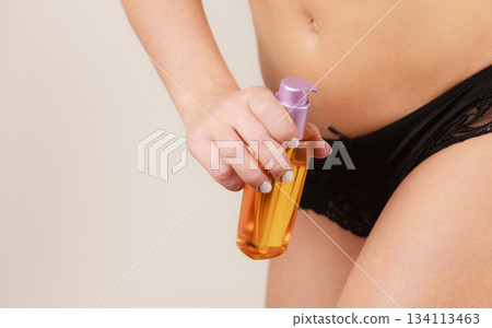 Woman applying moisturizing body oil lotion Woman applying moisturizing body oil lotion 134113463