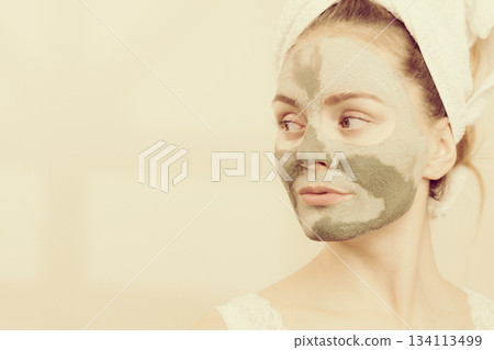 Woman face with green clay mud mask 134113499