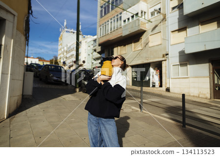 Relaxed lady and her pet soaking in evening city glow and atmosphere 134113523