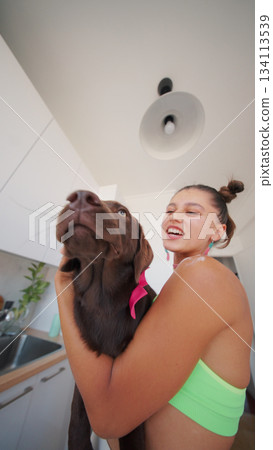 A Joyful and Heartwarming Moment Spent with a Chocolate Labrador in a Bright Kitchen Area 134113539