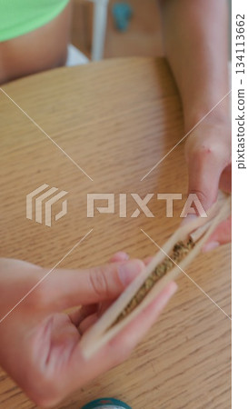 Engaging in the Rolling Process with All Natural Elements Carefully Arranged on a Wooden Table 134113662