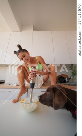 A vibrant and cozy kitchen scene featuring a cheerful dog engaged in cooking activities A vibrant and cozy kitchen scene featuring a cheerful dog engaged in cooking activities 134113670