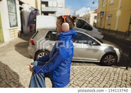 white person closeup with headphones looking upward in blue jacket white person closeup with headphones looking upward in blue jacket 134113740