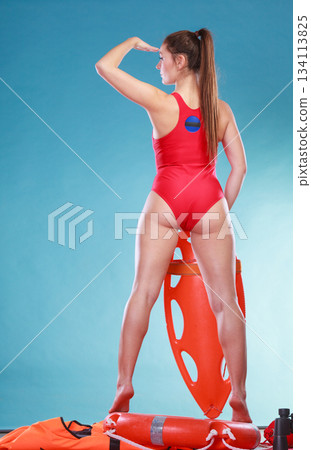Lifeguard on duty with rescue buoy supervising. 134113825