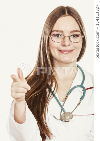Woman doctor with stethoscope pointing at you. Woman doctor with stethoscope pointing at you. 134113827