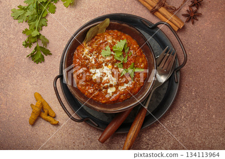 Dal makhani with cream and coriander in bowl is served with spices top view, traditional dish of India 134113964