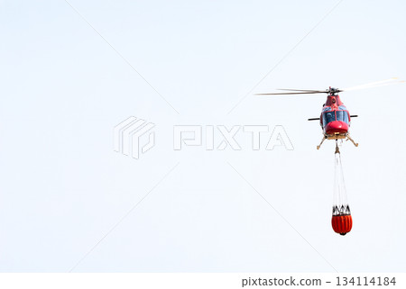Firefighting Helicopter Carrying Water in Clear Sky Firefighting Helicopter Carrying Water in Clear Sky 134114184