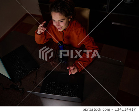 Young Creator Recording Podcast With Microphone And Laptop At Home Desk For Online Content Young Creator Recording Podcast With Microphone And Laptop At Home Desk For Online Content 134114417