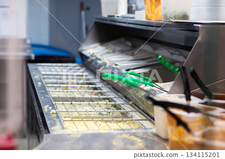Food station setup, Hygienic fastcasual food preparation area with condiments and utensils Food station setup, Hygienic fastcasual food preparation area with condiments and utensils 134115201
