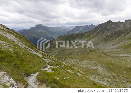 Exploring Smugglerpfad trail in Gargellen, Montafon with mountain views and cloudy skies Exploring Smugglerpfad trail in Gargellen, Montafon with mountain views and cloudy skies 134115475