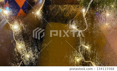 Abstract background of warm bokeh lights and vibrant colors seen through a rain covered window pane Abstract background of warm bokeh lights and vibrant colors seen through a rain covered window pane 134115568