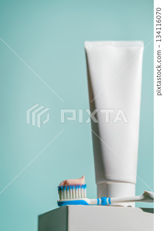 A toothbrush with a dab of pink toothpaste 134116070