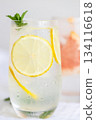 Glass of cold lemon water with mint garnish. 134116618