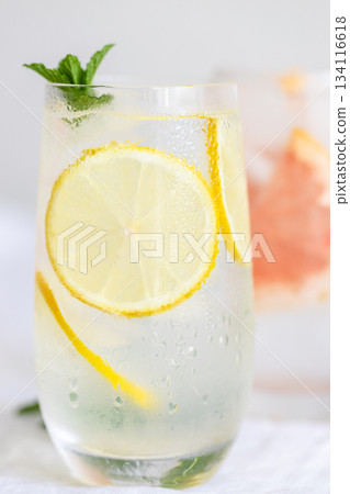 Glass of cold lemon water with mint garnish. 134116618
