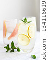 Glass of cold lemon water with mint garnish. 134116619