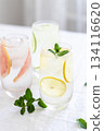 Glass of cold lemon water with mint garnish. 134116620