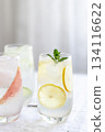 Glass of cold lemon water with mint garnish. 134116622