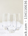 Three clear empty glasses on white tablecloth. 134116636