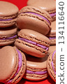 Many chocolate macarons on red background. 134116640
