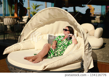 Tourist relaxing on comfortable round sunbed in luxury hotel resort enjoying summer vacation 134116776
