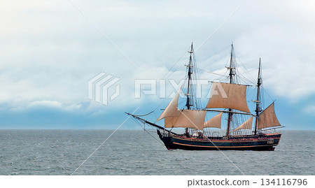 Tall ship sailing on ocean against cloudy sky 134116796