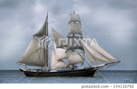 Tall ship sailing open sea under cloudy sky 134116798