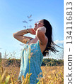 A woman in a sunny wheat field on a summer day 134116813