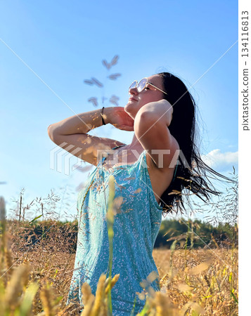 A woman in a sunny wheat field on a summer day 134116813