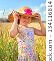 A joyful girl in a straw hat on a sunny day 134116814