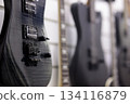 electric guitars hanging on a wall in music store 134116879