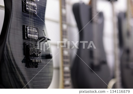electric guitars hanging on a wall in music store 134116879